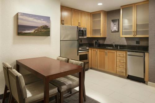 a kitchen with a wooden table and a dining room at Residence Inn San Diego Del Mar in San Diego