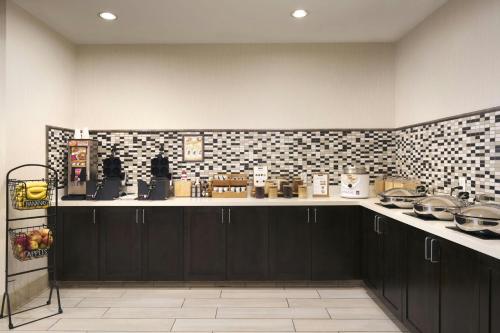 a kitchen with black cabinets and a tile wall at Residence Inn San Diego Del Mar in San Diego