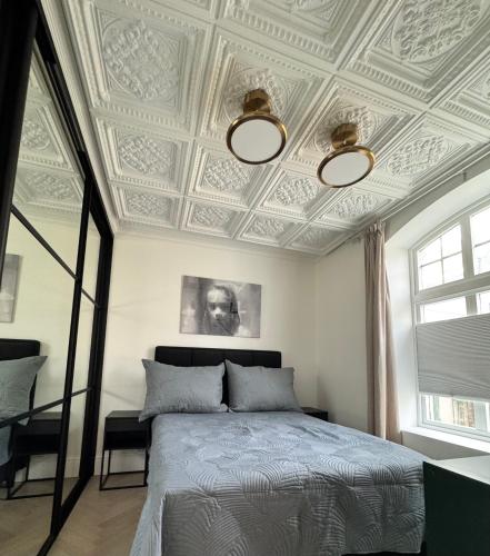 a bedroom with a bed with a coffered ceiling at Elegant Three-Bedroom Apartment with Stunning Sea Views - Very limited availability - Secure your booking for Christmas 2026 or Summer 2027 in Ålesund