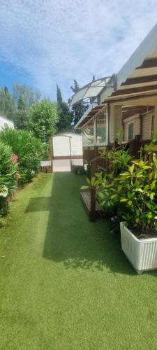 une cour avec de l'herbe verte et une maison dans l'établissement Envie d'évasion, à Fréjus