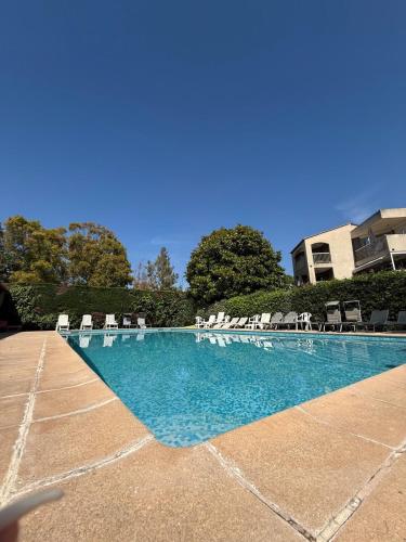 - une piscine avec des chaises et des chaises blanches dans l'établissement Appartement avec 2 chambres terrasse clim et piscine, à Antibes