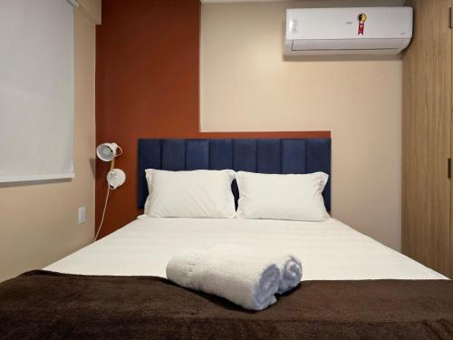 a bedroom with a bed with a blue headboard at Apê Ótima Localização, Cozinha, Coworking, Fitness in Maceió