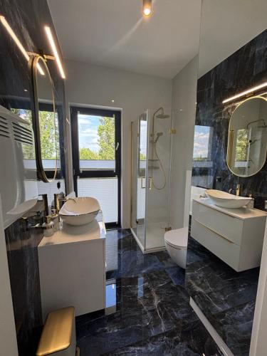 a bathroom with two sinks and a shower at Horizon Park 33 Boszkowo in Boszkowo
