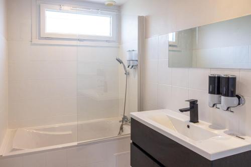 une salle de bain blanche avec un lavabo et une douche dans l'établissement Maison près de Disneyland, à Saint-Germain-sur-Morin