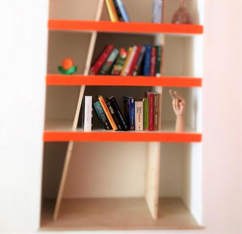 a book shelf filled with lots of books at The Rock Hostel in Matera