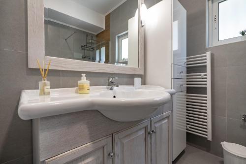 a bathroom with a white sink and a mirror at G&A Family Home near the Beach by MΡS in Nea Makri
