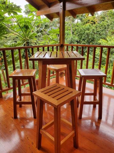 a wooden table and two stools on a porch at MAYU PATANPI Amazon Lodges in Tarapoto
