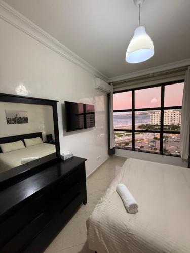 a bedroom with two beds and a view of the beach at Une pépite avec vue panoramique playa, Tanger in Oulad Akkou