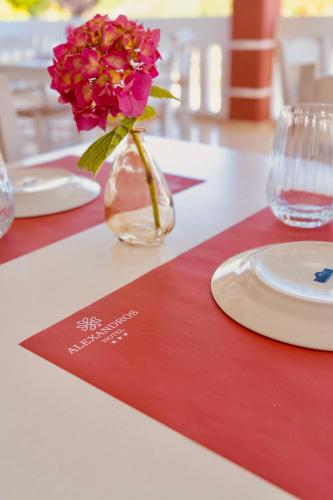 a vase with a flower in it on a table at Hotel Alexandros in Ammoudia