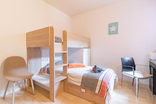 a bedroom with a bunk bed and a chair at Charming Garden Apartment en "Jardins de Sa Boadella" in Lloret de Mar
