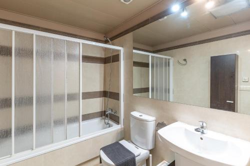 a bathroom with a toilet and a sink and a tub at Charming Garden Apartment en "Jardins de Sa Boadella" in Lloret de Mar