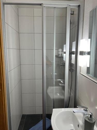 a bathroom with a shower and a sink at Gasthof Löwen in Pfronten