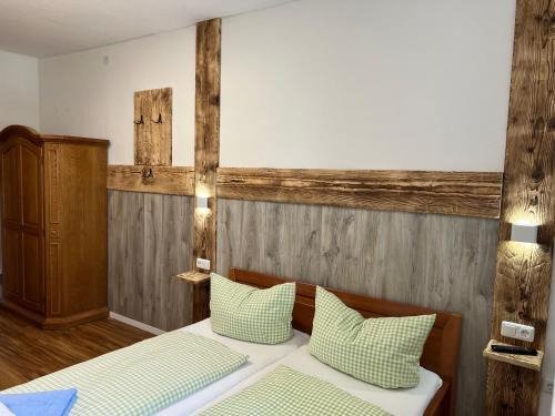 a bedroom with two beds with green and white pillows at Gasthof Löwen in Pfronten