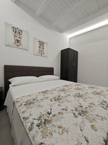 a bedroom with a large bed with a floral blanket at Case Victoria - Mamalu in Lampedusa