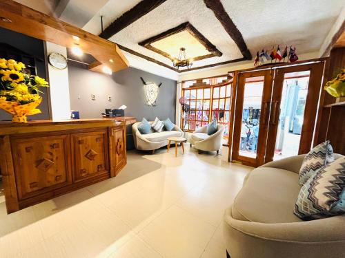 a living room with couches and a clock on the wall at Hotel Rojas Machupicchu in Machu Picchu