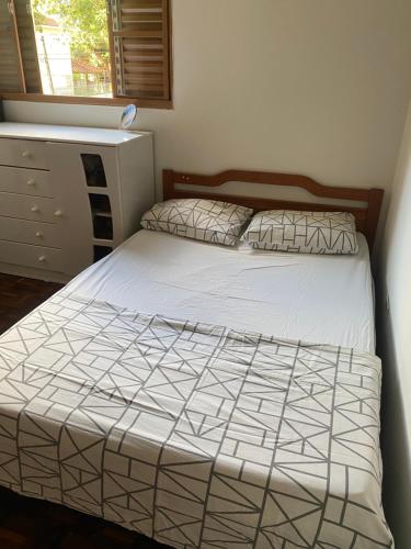 a bedroom with a bed and a dresser at Apartamento Zona 7 Maringá in Maringá