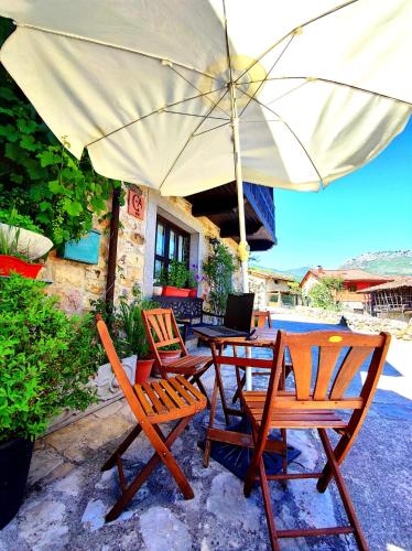 a table and chairs with an umbrella on a patio at Casa de Aldea El Torrexon in Villamorey
