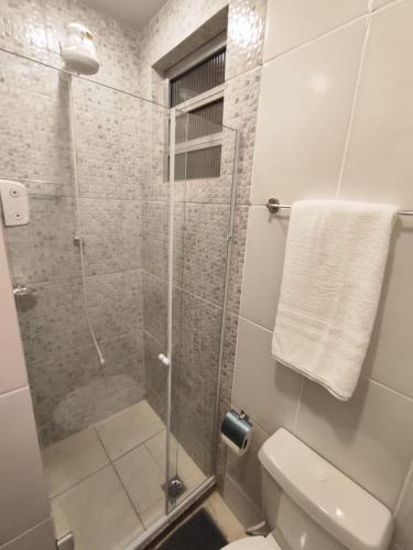 a bathroom with a glass shower with a toilet at Loft 220 Ar Cond Wi-fi com Box TV filmes e séries in Niterói
