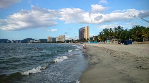 Casa Hotel Marly في سانتا مارتا: شاطئ مع أشخاص يسبحون في الماء