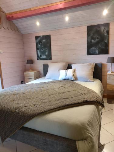 une chambre avec un grand lit dans une pièce dans l'établissement Les abris de la hulotte, à Anould