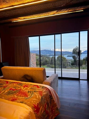 a bedroom with a bed and a large window at Crucero House in Cuítiva