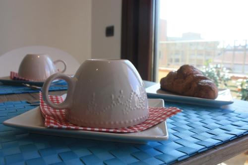 a table with a tea pot and a plate of pastries at Terrazzi in Fiore in Alghero