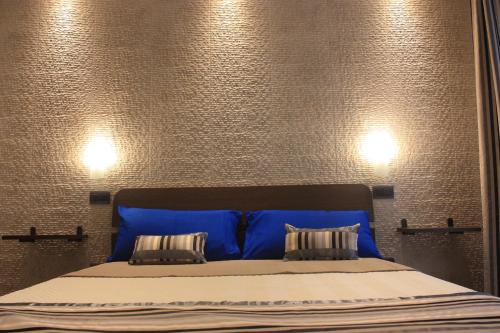 a bed with a blue headboard and two pillows at Terrazzi in Fiore in Alghero