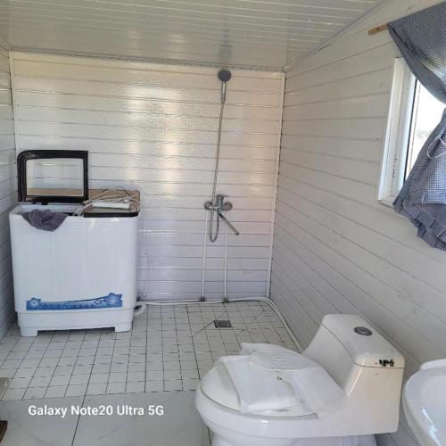 a white bathroom with a toilet and a sink at Tsaatan - Mother's Traditional Ger in Khyaktil