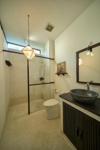 a bathroom with a sink and a toilet and a mirror at Kyara Arthouse Villa in Thanh Ðông (1)