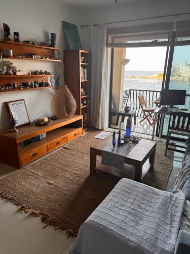 a living room with a bed a table and a balcony at Wake up to the gorgeous sunrise in Marsalforn