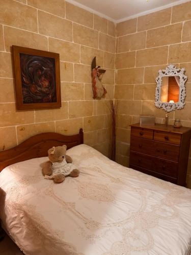 a teddy bear sitting on a bed in a bedroom at Wake up to the gorgeous sunrise in Marsalforn