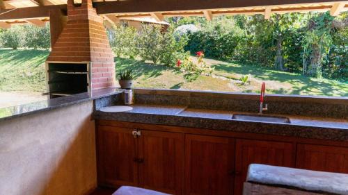 a kitchen with a sink and a brick oven at Casa junto as montanhas in Capitólio