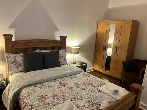 a bedroom with a large bed and a chair at Royal Apartments Edinburgh in Edinburgh