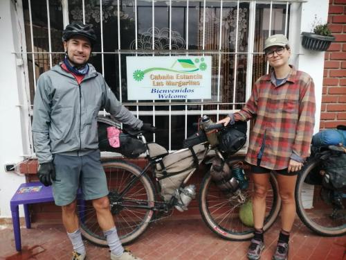 a man and a woman standing next to a bike at Hostal las margaritas in Pasto