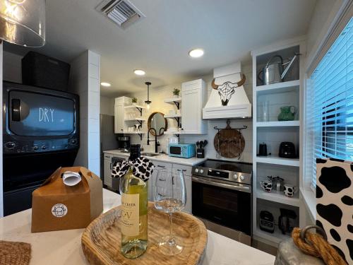 a kitchen with a table with wine glasses and a tv at Walk to Best Eats and Shops and Stay in Style in Fort Myers
