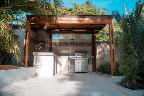an outdoor kitchen with a grill under a pergola at Star Apple Inn in San Andrés