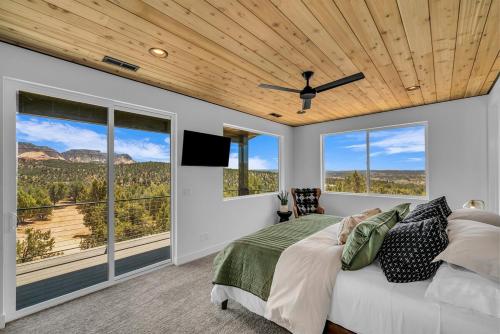 1 dormitorio con 1 cama, ventilador de techo y ventanas en High Desert Home Modern Luxury Near Zion NP, en Orderville