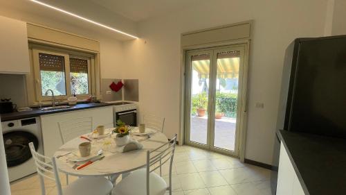 a kitchen with a white table and chairs and a sink at Casa Sciarelli in Aci Castello