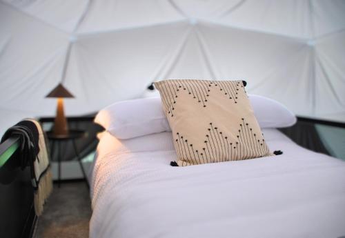 Una cama en una tienda con una almohada. en Kilima Retreats, en West Quantoxhead