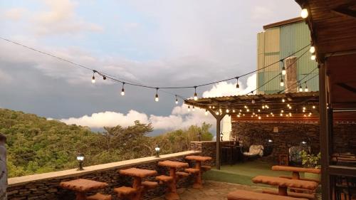 a patio with a bunch of benches and lights at Cabinas Vista Al Golfo in Monteverde Costa Rica