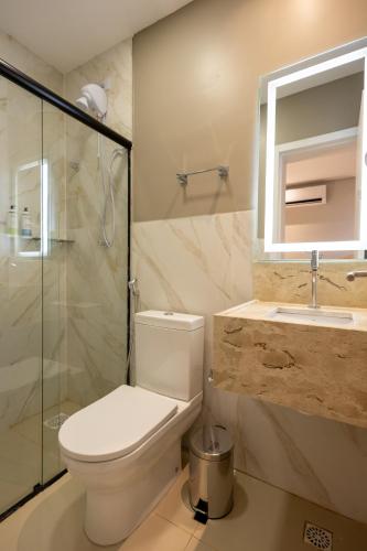 a bathroom with a toilet and a shower and a sink at Aira Hotel in Sobral