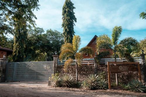 a fence in front of a house with trees at Star Apple Inn in San Andrés