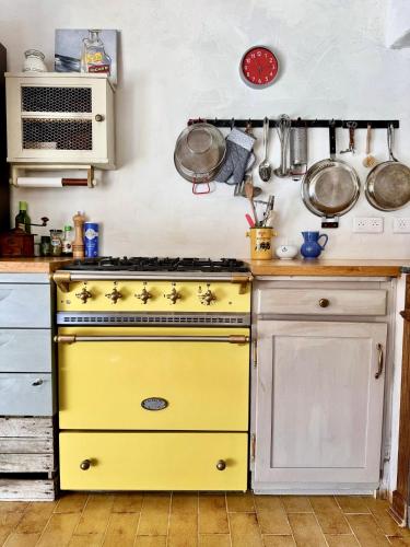 a yellow stove in a kitchen with pots and pans at La Mistraline, 2 bedrm 2 bath house in the heart of Provence in Caseneuve