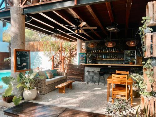 a patio with a bar with a couch and a table at Mimosa Tulum in Tulum