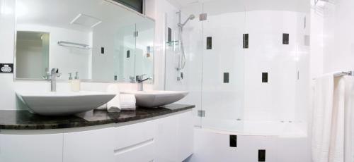 a white bathroom with two sinks and a shower at Poinciana 112 Bedrooms x3 Free Buggy in Hamilton Island