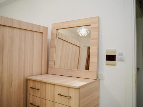 a bathroom with a mirror and a wooden cabinet at Deve Mar Hotel in Borsh