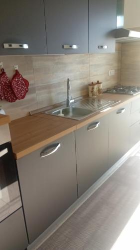 a kitchen with white cabinets and a sink at A casa di paola in Naples