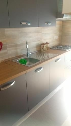 a kitchen with a sink and white cabinets at A casa di paola in Naples