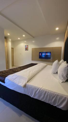 a bedroom with a large bed with a tv on the wall at Lucy and Jacobs Luxury Apartment in Port Harcourt