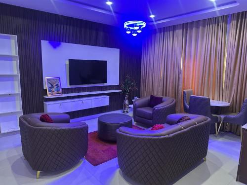 a living room with two chairs and a television at Lucy and Jacobs Luxury Apartment in Port Harcourt